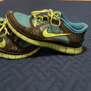 Teal and neon green Nike Free Runs that are used.